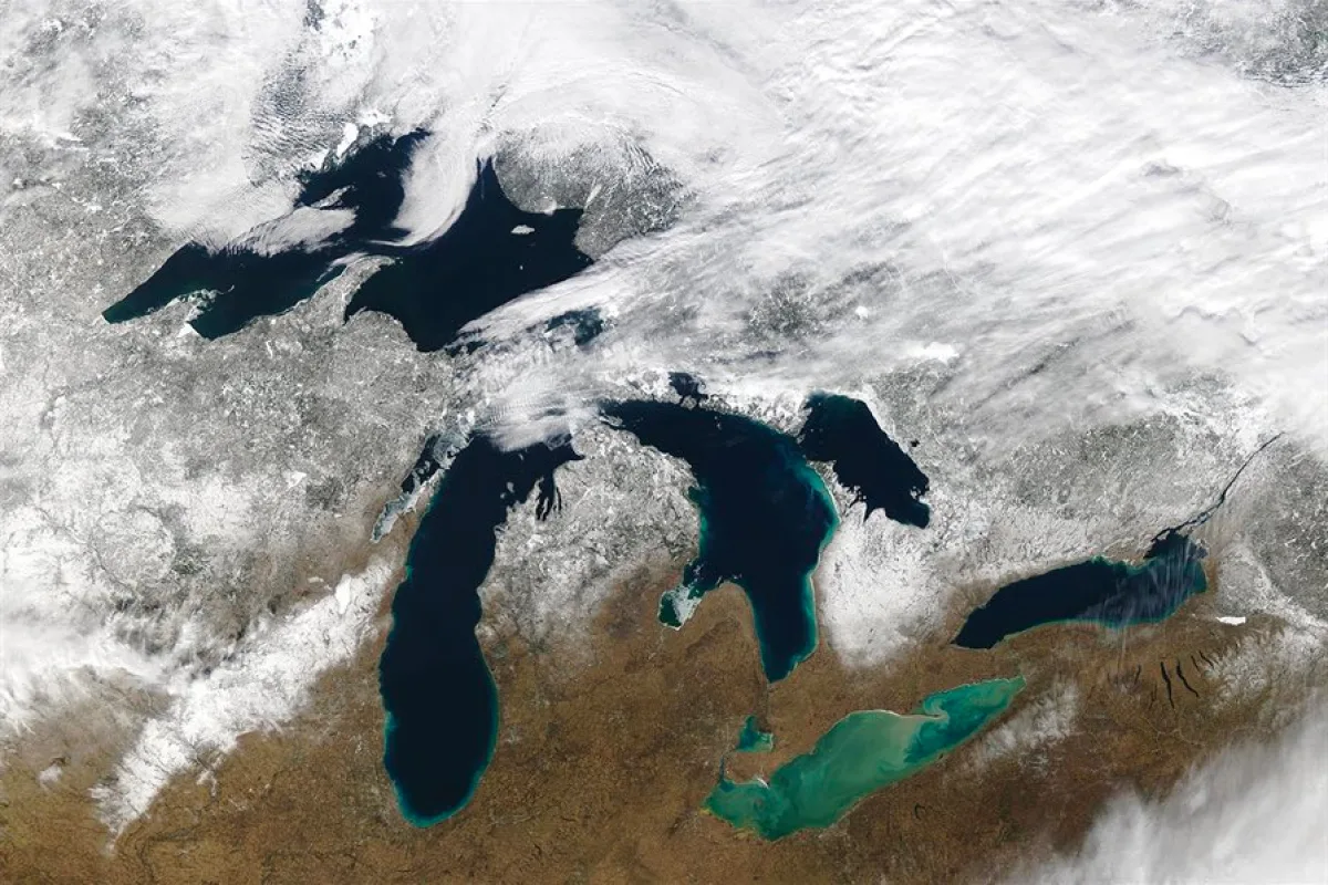 Satellite view of the Great Lakes showing minimal ice coverage during winter 2024, highlighting climate change effects on regional ecosystems and human activities.